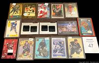 Photo of multiple hockey cards laid out in rows showing varying designs with player images, logos and memorabilia inserts.