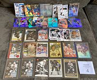 Top-down view of 58 Wayne Gretzky hockey cards laid out on a sofa, showing multiple cards in protective sleeves including inserts and base cards from different sets circa 1990-2000.