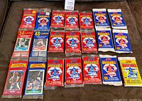 Full lot image showing 18 sealed Score baseball card packs from 1988-1990 arranged on a dark surface.