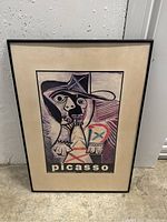 Full view of the framed Picasso art print showing abstract portrait and beige matting