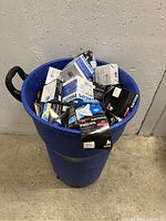 Blue bin filled with multiple boxes of Philips light bulbs, showing quantity and packaging type.