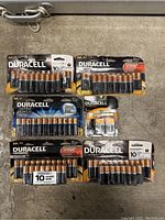 Photo showing multiple packs of Duracell AA CopperTop and Ultra Power batteries, plus a 4-pack of 9V CopperTop batteries laid out on surface.