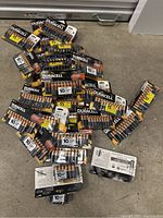 Multiple packs of Duracell AA batteries scattered on floor including 10 and 15 pack sizes.
