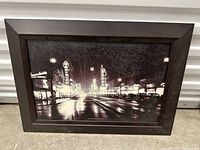 Framed photo of a nighttime street scene on Granville Street in Vancouver with cars and illuminated signs.