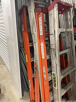 Side view of five ladders stacked closely together showing brand labels Featherlite and Allright.