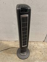 Full view of Lasko tower fan showing front grille and base.