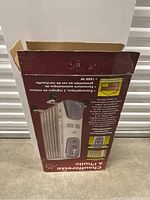 Original box of the oil heater showing product image and specifications in Spanish.