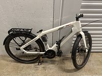 Full side profile of white Urban Plus e-bike showing frame, wheels, rack and fenders