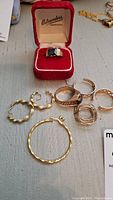 Overview showing rings in center and hoop earrings at left