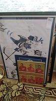 Image showing a large framed Toronto Maple Leafs player poster with visible signature and smaller framed items in front.