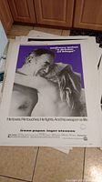 Photo of the 'A Season of Slaves' vintage movie poster showing close up of couple in embrace with purple background and white border text.