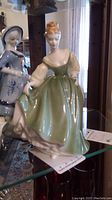 Front angle of Royal Doulton Fair Lady porcelain figurine showing green dress and detailed face with red hair.