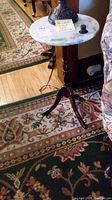 Full view of round marble top table next to sofa showing overall appearance and scale