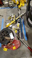 Overview of various come alongs with metal handles, red hoist, and cable spool.