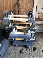 Six wooden Haul Master movers dollies stacked, showing caster wheels and carpet padding.