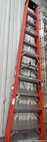 Full side view of red Werner fiberglass ladder