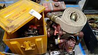 Yellow steel box with latch and 'GENERATOR' stencil containing a red and silver compact generator engine