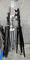 Photo showing the three industrial tripods in black, silver/white, and black colors leaning against a wall.