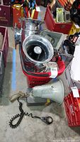 Overview of red crate containing horn speakers, grey megaphone on floor, coiled mic cable