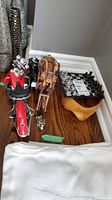 Chess set, motorcycle figurine and wooden sculpture on wooden surface, corner view