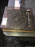 Top view of Dual 506 turntable with plastic dust cover, power cord tangled on top.