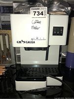 Front view of white GranGaggia machine showing brand logo and drip tray