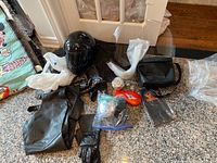 Photo of entire collection laid out on floor including helmet, chaps, gloves, small bags, and miscellaneous Harley Davidson branded items.