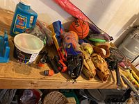 Table with kids baseball gloves, softballs, Franklin baseball bat, basketball, Nerf football, bubbles, chalks, and kite in packaging.