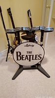 Frontal view of Ludwig Beatles drum kit controller assembly including bass drum pad and four drum pads on stand.