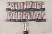 Full view of all 17 pink facial hair removers in their packaging, arranged on a table, with USB cables and replacement heads visible inside each package.