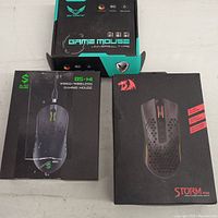Photo showing the original boxes of the three gaming mice: Zerodate, Black Shark BS-MI, and Redragon Storm Pro.
