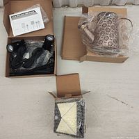Three solar garden lighting items displayed: two box-packaged solar spotlights with stakes and cables, and one decorative watering can-shaped solar light in own box.