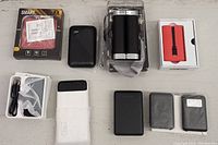 Overview photo showing all 9 power banks with some in packaging and some loose on the surface