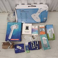 Overview photo showing all item boxes including bidet attachment, electric scrubber, toilet brush, dispensers, repair parts, grout marker, and hooks.