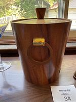 Close-up of teak ice bucket with lid and gold-tone metal ring handle