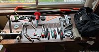 Wide view of all plumbing tools and accessories on a wooden table next to a window
