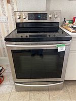 Front view of stainless steel stove showing cooktop, control panel and oven door