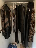 Hanging garments from left: patterned suit jacket, camisoles, skirts, pants, scarf