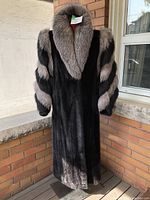 Full-length front view of black mink coat with silver fox collar and sleeves on mannequin