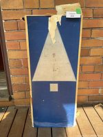 Worn blue box front panel showing triangular tree graphic and lot sticker