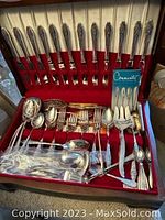 Full view of the complete silver plate flatware set in a velvet lined wooden case showing multiple place settings including knives, forks, spoons, and serving utensils.