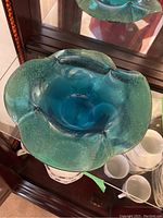 View of the blue-green art glass bowl showing color gradient and petal-shaped edges