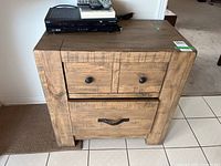 Front view of the wood cabinet, showing two drawers and distressed finish.