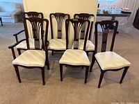 Front view of six dining chairs, four without arms and two with arms.