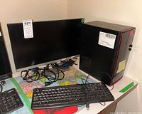 Photo showing Dell Inspiron desktop tower with Logitech K120 keyboard and AOC monitor all placed on a table, cables connected or visible.