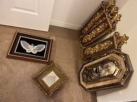 Overview photo showing all items in the lot on carpet: two mirrors, framed butterfly, and four plaques grouped together for size and framing details.