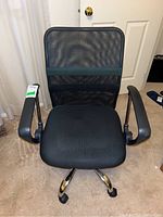 Front view of the black mesh office chair showing the seat, mesh back, armrests, and caster base.