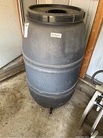 Front view of rain barrel showing its shape, color, and spigot at base.