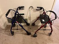 Photo showing a blue folding metal walker with brakes and plastic seat, a red folding metal walker with brakes and plastic seat, and one adjustable metal cane.