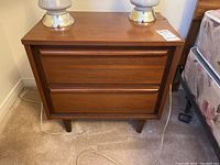 Front view of one side table with two drawers and integrated wood pulls